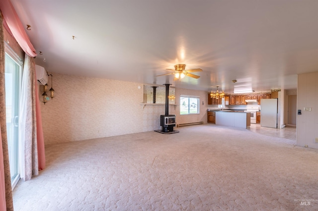 50 S 200 W, Jerome, ID 83338 - unfurnished living room with light colored carpet, baseboard heating, ceiling fan with notable chandelier, a wall mounted AC, and a wood stove