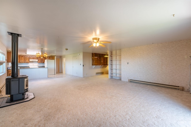 50 S 200 W, Jerome, ID 83338 - unfurnished living room with baseboard heating, a wood stove, light carpet, and ceiling fan with notable chandelier