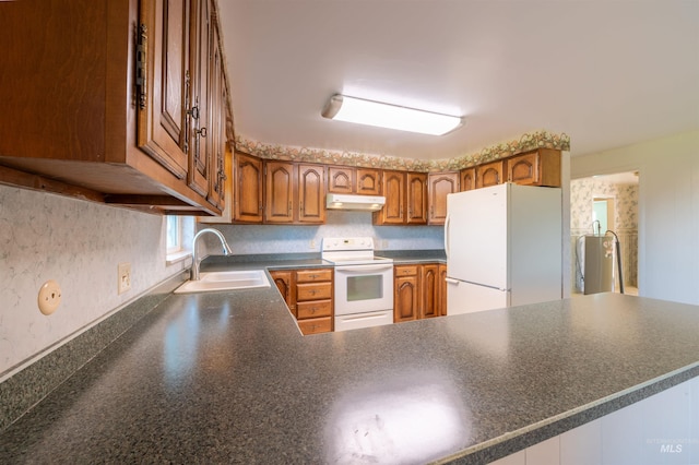 50 S 200 W, Jerome, ID 83338 - kitchen featuring white appliances, under cabinet range hood, brown cabinets, dark countertops, and a sink