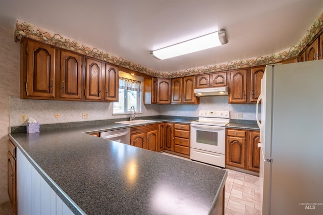 50 S 200 W, Jerome, ID 83338 - kitchen with white appliances, brown cabinetry, under cabinet range hood, dark countertops, and a sink