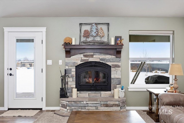 living area with a fireplace and baseboards