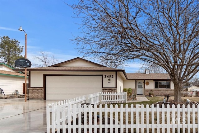 ranch-style house with driveway, roof with shingles, an attached garage, a fenced front yard, and brick siding