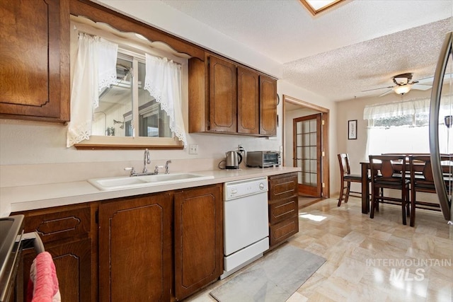 kitchen with light countertops, white dishwasher, a textured ceiling, a ceiling fan, and a sink