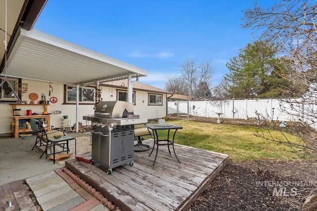 deck with a lawn, a fenced backyard, and grilling area