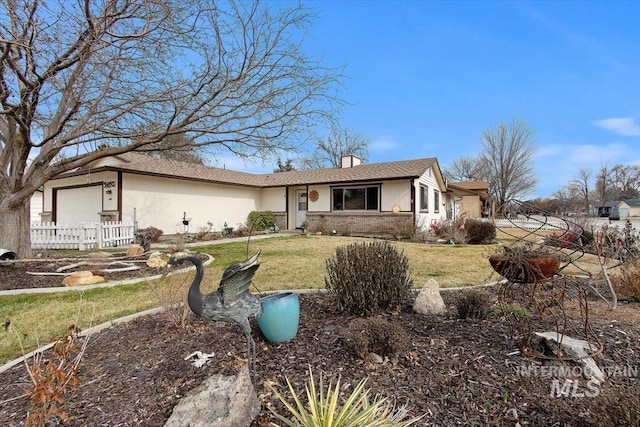 view of front of home featuring brick siding, a front yard, and a garage