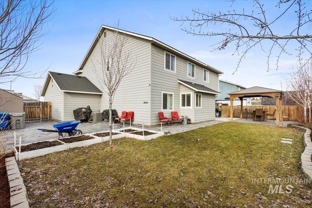 rear view of property featuring a gazebo, a patio area, and a yard