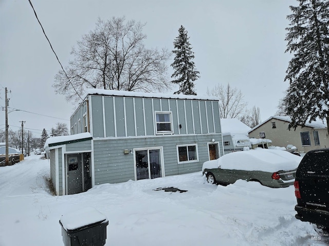 view of snow covered rear of property