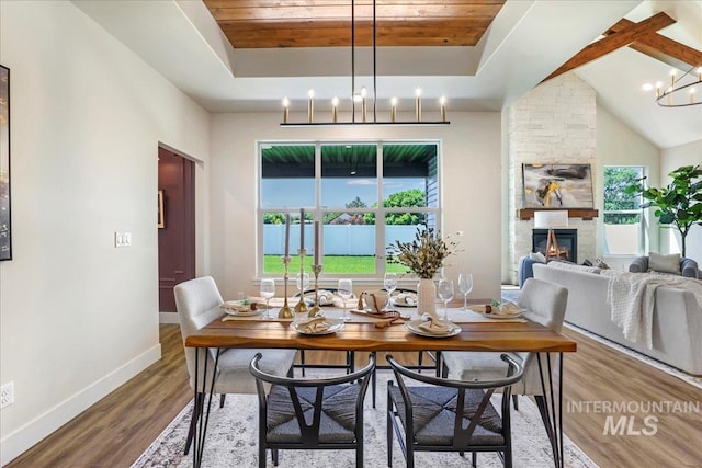 3160 Crescent Moon Rd, Twin Falls, ID 83301 - dining space with a chandelier, a raised ceiling, wood finished floors, a fireplace, and wooden ceiling