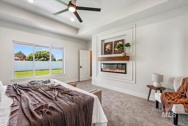 3160 Crescent Moon Rd, Twin Falls, ID 83301 - carpeted bedroom with a glass covered fireplace, a tray ceiling, recessed lighting, and ceiling fan