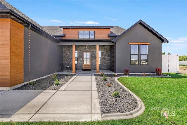 3160 Crescent Moon Rd, Twin Falls, ID 83301 - doorway to property featuring a lawn, stucco siding, a porch, a shingled roof, and stone siding