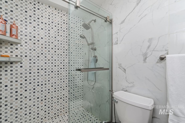 7913 W War Bonnet Dr, Boise, ID 83709 - bathroom featuring a stall shower, tile walls, and toilet