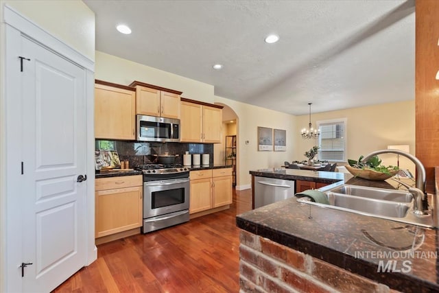 187 E Wishbone Ct, Boise, ID 83706 - kitchen with appliances with stainless steel finishes, light brown cabinetry, arched walkways, a sink, and recessed lighting