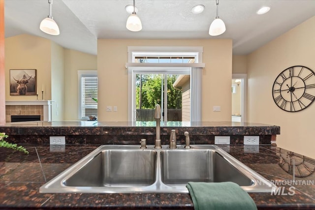 187 E Wishbone Ct, Boise, ID 83706 - kitchen with a sink, tile countertops, pendant lighting, and a fireplace
