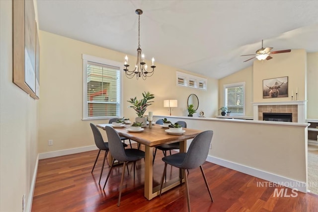 187 E Wishbone Ct, Boise, ID 83706 - dining room featuring a chandelier, healthy amount of natural light, a tiled fireplace, dark wood-style flooring, and lofted ceiling