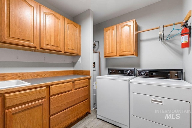 14 Sunrise Dr, Garden Valley, ID 83622 - laundry area featuring light wood-type flooring, cabinet space, independent washer and dryer, and water heater