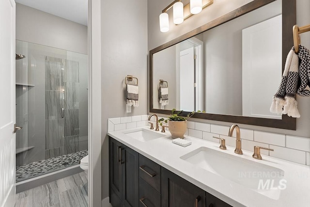 5557 E Hootowl Dr, Boise, ID 83716 - bathroom featuring double vanity, toilet, a stall shower, and decorative backsplash