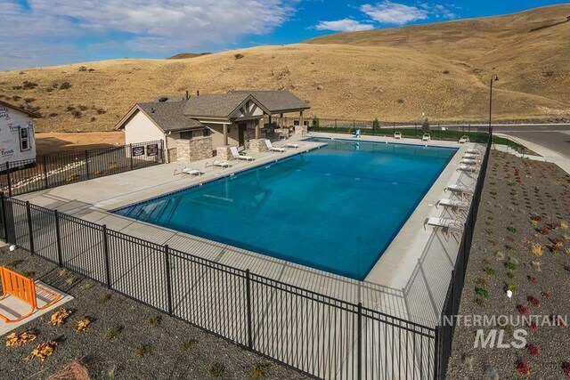 5557 E Hootowl Dr, Boise, ID 83716 - community pool with a mountain view and a patio area