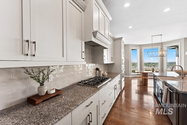 5557 E Hootowl Dr, Boise, ID 83716 - kitchen with appliances with stainless steel finishes, a sink, dark wood-style flooring, backsplash, and recessed lighting