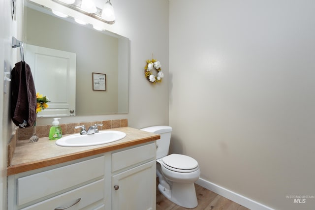 6524 S Derbyshire Ave, Boise, ID 83709 - half bath featuring toilet, vanity, wood finished floors, and baseboards