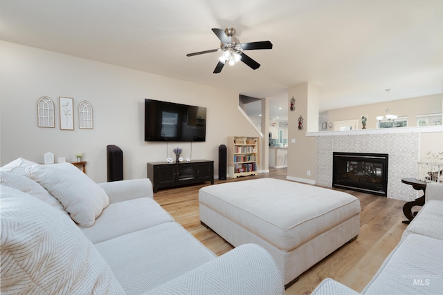 6524 S Derbyshire Ave, Boise, ID 83709 - living room with light wood-style floors, ceiling fan, a chandelier, and a fireplace