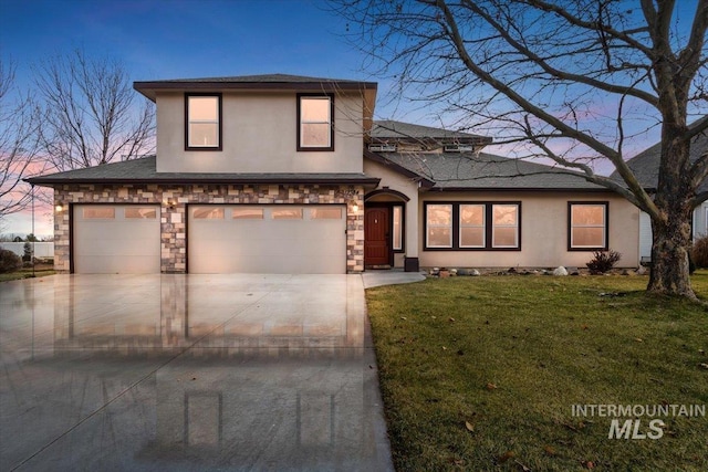 view of front of home with a garage and a lawn