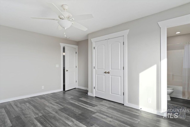 unfurnished bedroom featuring ceiling fan, dark hardwood / wood-style floors, a closet, and ensuite bathroom