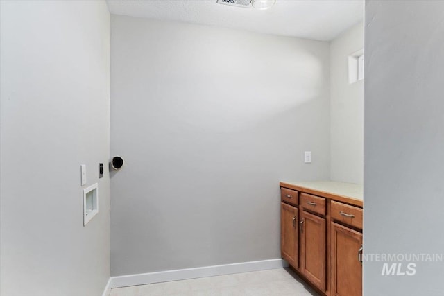 clothes washing area featuring washer hookup and cabinets