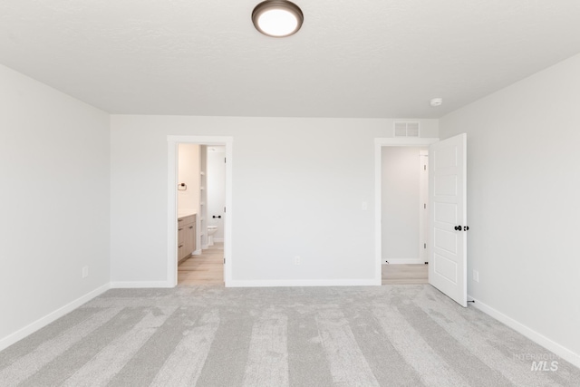 2455 W Opalite Dr, Kuna, ID 83634 - unfurnished bedroom with light carpet, baseboards, and ensuite bathroom