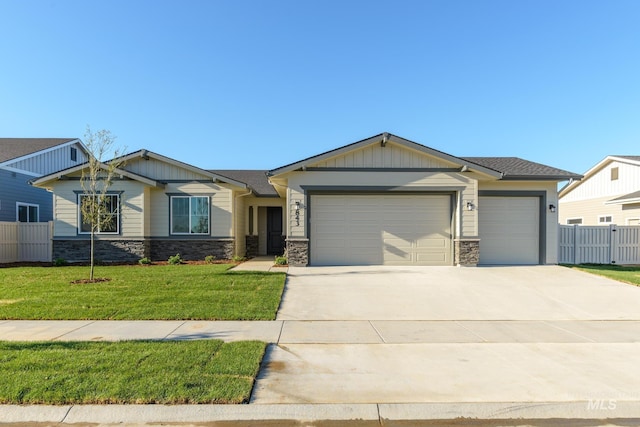 view of front of property featuring driveway, an attached garage, a front lawn, and fence