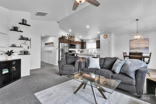 living area with light carpet, a ceiling fan, baseboards, lofted ceiling, and visible vents