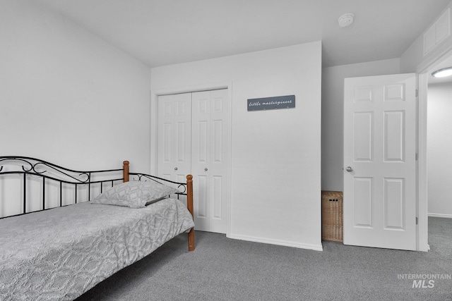carpeted bedroom featuring baseboards and a closet