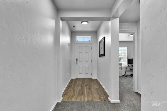 entryway featuring baseboards, carpet, and visible vents