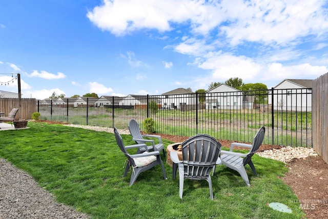 view of yard featuring an outdoor fire pit and fence