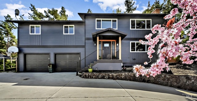 view of front of home with an attached garage, a chimney, and driveway
