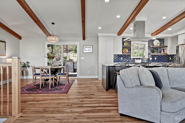 living room with beamed ceiling, baseboards, light wood-type flooring, and recessed lighting