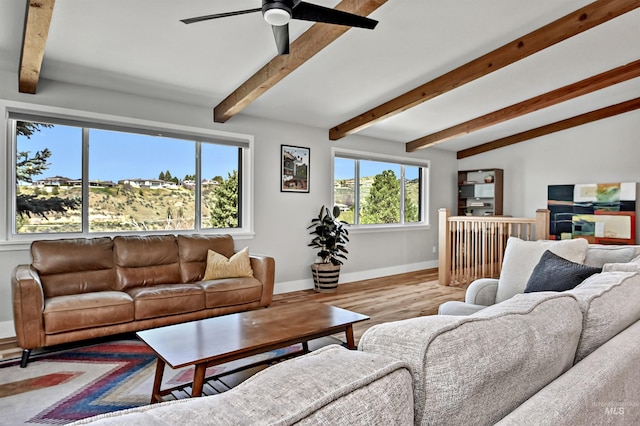 living room featuring vaulted ceiling with beams, baseboards, a ceiling fan, and wood finished floors
