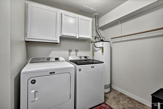 clothes washing area with visible vents, water heater, washing machine and clothes dryer, baseboards, and cabinet space