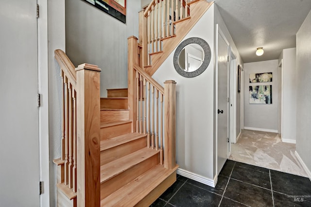 stairway with tile patterned flooring and baseboards