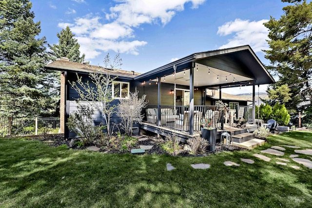 back of property featuring a yard and a wooden deck
