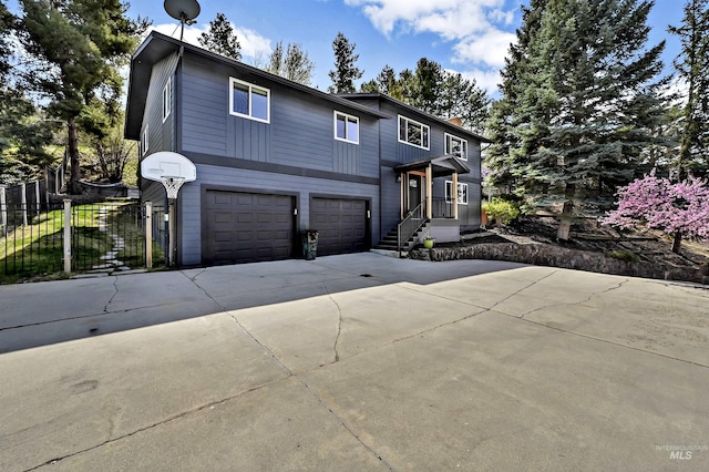 view of front of house featuring driveway, fence, and an attached garage