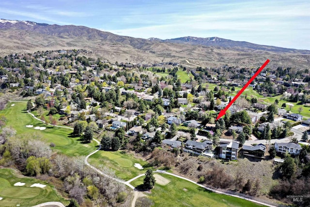 drone / aerial view with view of golf course, a residential view, and a mountain view