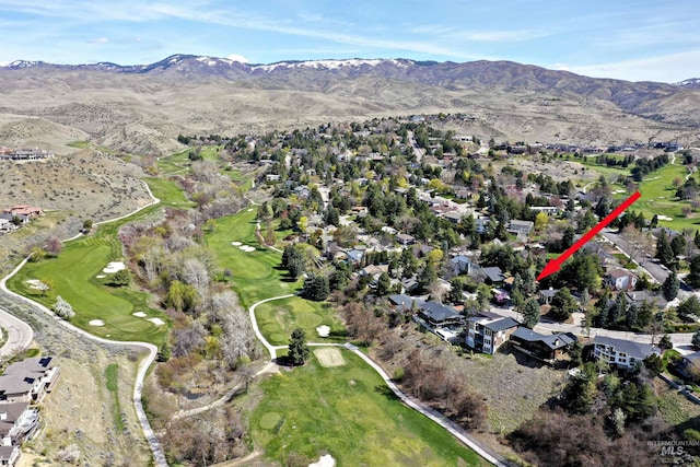drone / aerial view featuring golf course view, a mountain view, and a residential view