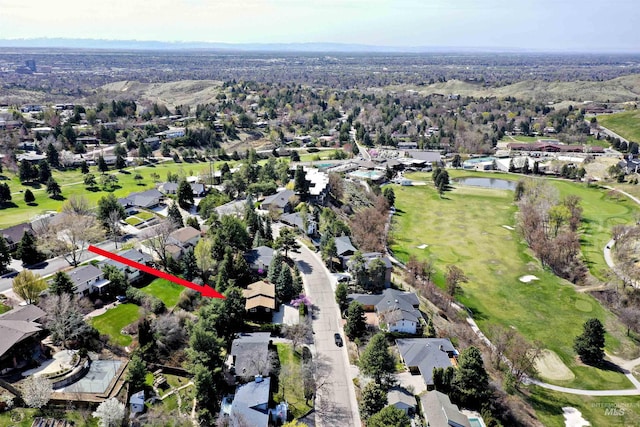 drone / aerial view featuring view of golf course and a residential view