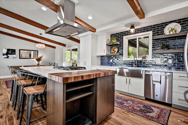 kitchen featuring island exhaust hood, white cabinetry, open shelves, wooden counters, and stainless steel appliances