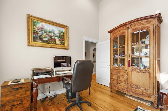 home office with baseboards and wood finished floors