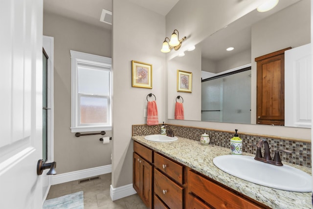 full bath with a stall shower, baseboards, visible vents, and a sink