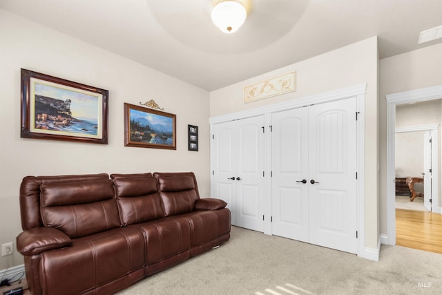 living room with baseboards and light colored carpet