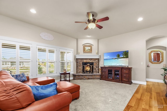 living room with baseboards, ceiling fan, light wood-style floors, a fireplace, and recessed lighting