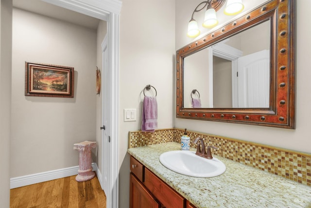 bathroom with baseboards, wood finished floors, and vanity