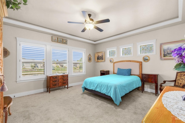 carpeted bedroom featuring baseboards, a tray ceiling, and a ceiling fan